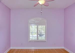 Located on your left at the top of the stairs, first guest bedroom with window view of the front and fountain.