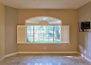 As you step into this home the view runs through to the back living area, offering a view of foliage and a pond.