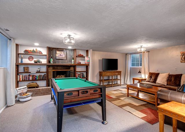 Lower Level Family Room with Large Stone Fireplace, Pool Table, 55" Smart TV  and Comfortable Seating