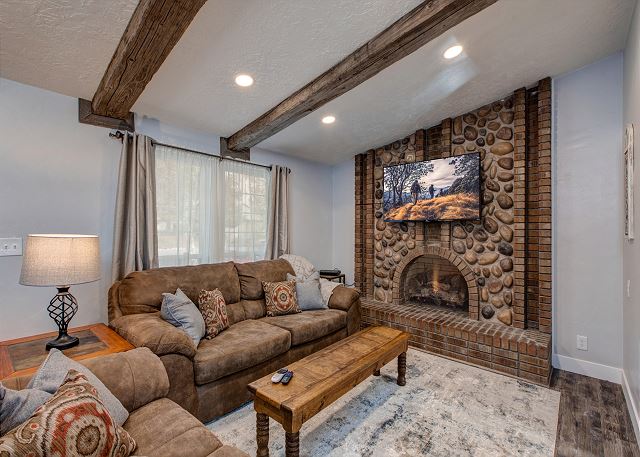 Main Level Living Area with Comfortable Seating, TV and Large Stone Fireplace