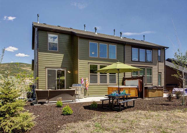 Rear exterior with comfortable seating, dining table, hot tub, patio heater and BBQ