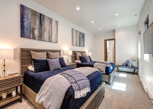 On the first/garage level you will find the fourth master bedroom, featuring two queen-size beds, a 50" Smart TV and Sonos, and a private bathroom with dual sinks and a tile walk in shower