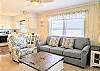 Interior view of D4 Briar Court featuring soft yellow walls, white trim, and beach-themed furniture accents.