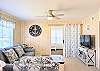 Bright, open-concept living area at D4 Briar Court featuring a grey sofa, coastal blue armchairs, and nautical decor.