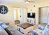 Detailed view of the living room at Bethany Meadows featuring anchor wall art and beach-themed accent pillows.