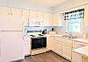 Well-equipped white kitchen in D4 Briar Court featuring ample counter space and a bright window over the sink.