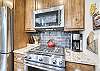 Stainless steel appliances including fridge, dishwasher, oven, and above range microwave.