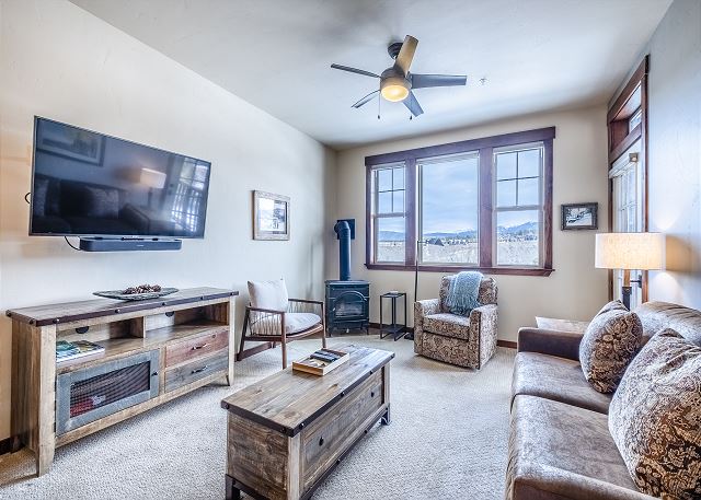 Flat screen TV, large window with views, access to the private balcony, and a gas fireplace.