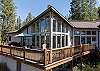 Front view of the home that accentuates the large windows and deck. 