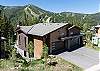 Aerial view of the home and the mountain landscape behind. 