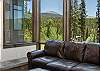 Mountain views over the tree line through the large windows of the living area. 