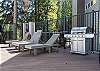 Communal amenity deck offers lounge seating and propane grill. 