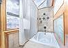 Large soaking tub and shower with sky lights above.
