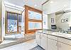 Large soaking tub with shower, separate vanity area, and a water closet around the other side.