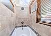 Large soaking tub with shower. Sky lights above allow for natural lighting.