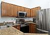 Kitchen with granite counter top and stainless steel appliances. 