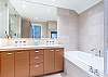 Modern ensuite master bathroom with adjoining gas fireplace to bedroom