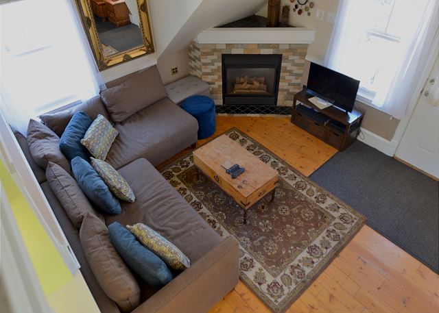 The living room area has a comfortable sofa, a cozy fireplace, and a smart TV. 