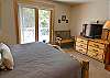 This master bedroom is delightful with a view of the Breckenridge Ski Resort, private balcony, King-sized bed, TV, and private bathroom. 