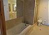 Private, master bathroom with jetted jacuzzi bath, shower and vanity. 