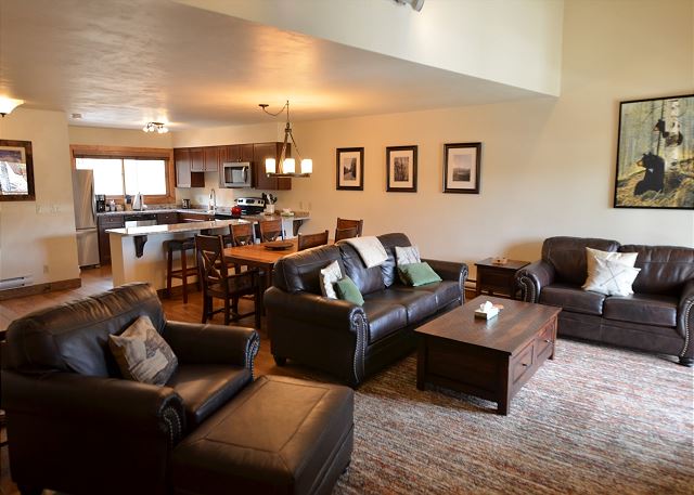 The main level of this condo has an open layout with the living room area, dining room, and fully equipped kitchen. The living room area has two, comfortable sofas, one is a sofa sleeper, a TV, and a gorgeous stone fireplace. 