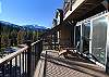 Large deck with a hot tub, sitting area, grill, and stunning views of the mountains.