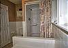 Full bathroom with walk in shower and jetted tub 