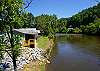 View of back of home and river right behind cabin. 