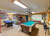 Game room with pool table, table tennis, and TV and seating area. 