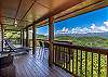 Covered deck with lounge seating and views of the mountains. 