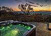 Uncovered hot tub on back patio facing beautiful mountain scenery. 