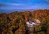 Aerial view of home surrounded by beautiful fall foliage. 