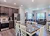 Kitchen with new stainless steel appliances and dining table with seating for 6. 