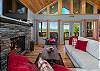 Cozy living room with stone fireplace, and mountain views through the windows.