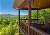 Covered side deck nook with a picnic table and peaceful mountain and treetop views.