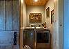 Charming laundry room with a sliding barn door and full-size washer and dryer.