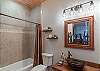 Guest bath with a copper vessel sink, and rustic wood vanity on the lower level. 