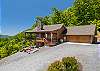 Front approach view with gravel driveway and entrance deck.