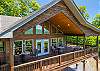 Front gabled deck section with soaring ceiling, barrel seating, and French door entry.