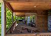 Main covered deck with picnic table, barrel table seating, and a hot tub at the far end.