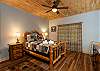 Cozy queen bedroom on the lower level with a rustic log bed. 