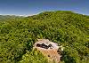 Aerial overview of the full property including cabin, decks, fire pit, and driveway.