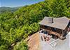 Close aerial view of the fire pit circle with red chairs and lower patio area. 