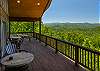 Open upper deck with barrel tables and chairs overlooking the mountains.