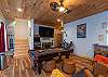 Full game room with arcade machine, pool table, flat-screen TV, and high-top seating. 