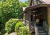 Stone-accented porch entrance with rocking chair, ceiling fan, and warm exterior lighting.
