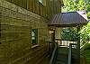 Ground-level view of the cabin's secondary entry with covered stoop.