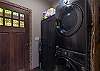 Stacked washer/dryer unit with storage cabinet.