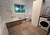 Main bathroom with shower over bath and laundry facilities
