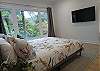 Main bedroom with comfortable queen bed and garden and mountain views. 